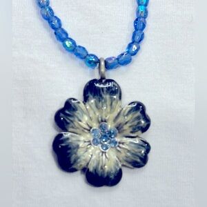 Fun flower pendant on blue beaded necklace